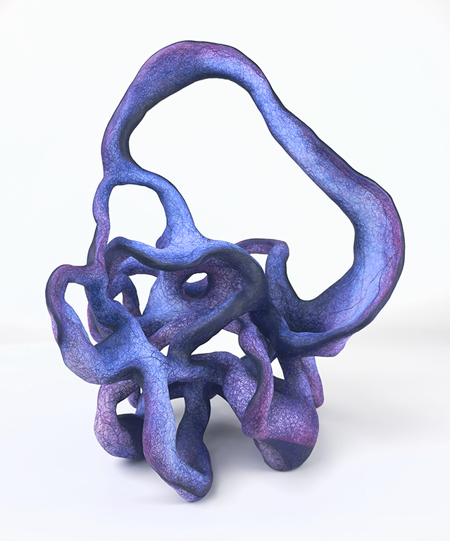 A sculptural artwork featuring abstract, flowing forms in shades of purple and blue, set against a plain white background.